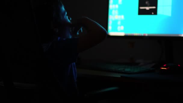 Niño asiático tarde en la noche lanza el juego en el ordenador, escribiendo algo interesante navegar por Internet, la luz de la luna brilla desde la ventana. Vista de cerca. Vídeo en cámara lenta. material de archivo — Vídeos de Stock