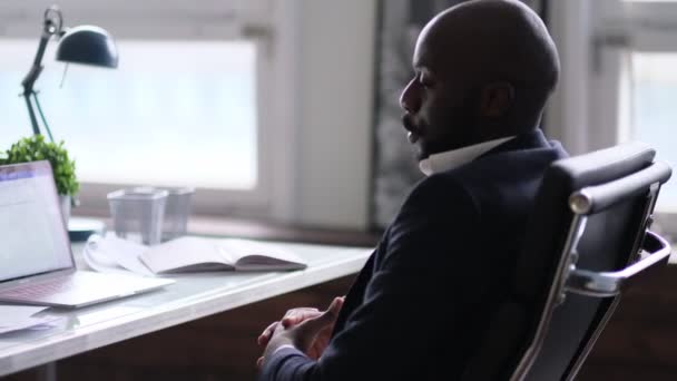 Trabalhador relaxado terminou a tarefa completada tendo pausa após o dia de trabalho duro colocando a cabeça na mão. Empresário afro-americano atencioso olhando pela janela sentado na mesa do escritório — Vídeo de Stock