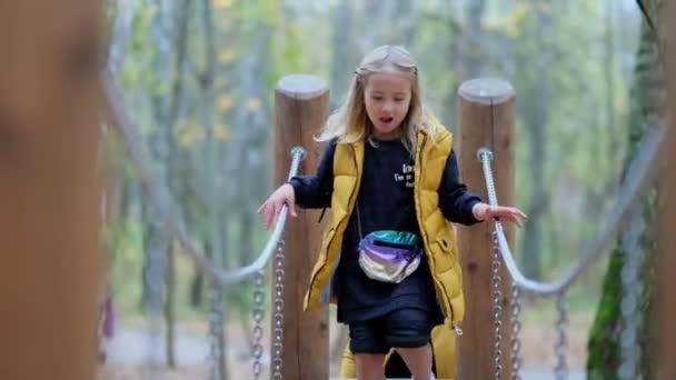 Portrait d'une petite fille souriante courant dans le parc. Joyeux enfant dans le parc. Vidéo au ralenti. images de stock — Video