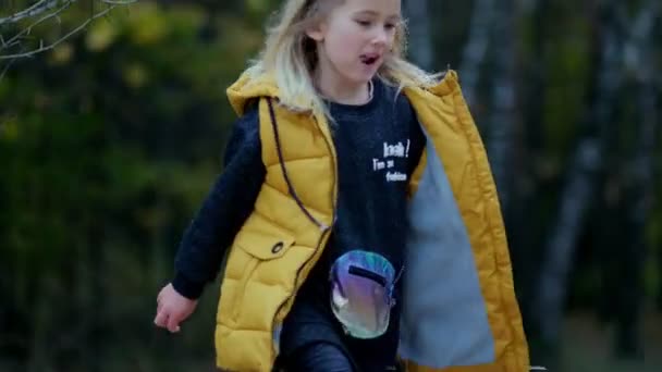 Portrait d'une petite fille souriante courant dans le parc. Joyeux enfant dans le parc. Vidéo au ralenti. images de stock — Video