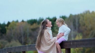 Kız annesiyle, annesi kızıyla vakit geçiriyor. Mutlu aile parkta birlikte vakit geçirir. Nesiller arası ilişkiler. Yavaş çekim videosu. depolama görüntüleri