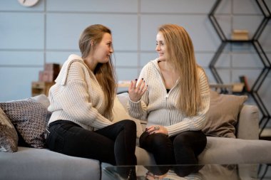 Mutlu kıdemli anne, yetişkin kızı kucaklıyor birlikte gülüyor, heyecanlı yaşlı kadın sarılıyor, farklı nesillerden gelen samimi aile şakalaşıyor, eğleniyor.