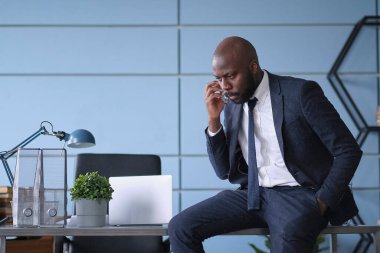 kızgın genç Afrikalı Amerikalı iş adamı. Girişimci küçük bir ofiste ya da evde dizüstü bilgisayara kızgın ve öfkeli.