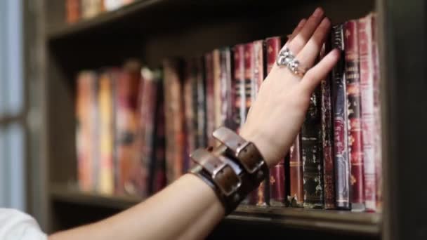 Élégant homme habillé choisit un millésime de livre vintage dans une vieille bibliothèque sombre. vue rapprochée. vue rapprochée. Mouvement lent nvideo. — Video