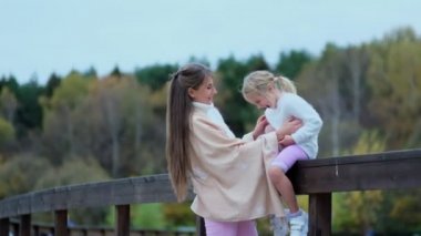 Kız annesiyle, annesi kızıyla vakit geçiriyor. Mutlu aile parkta birlikte vakit geçirir. Nesiller arası ilişkiler. Yavaş çekim videosu. depolama görüntüleri