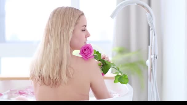 Beautiful Sexy Caucasian Blonde Girl In Bikini Lying In Flower Bath In Resort Day Spa Salon. Skin Care Therapy. Concept young woman relaxing in the bathtube. Slow motion video. stock footage — Stock Video