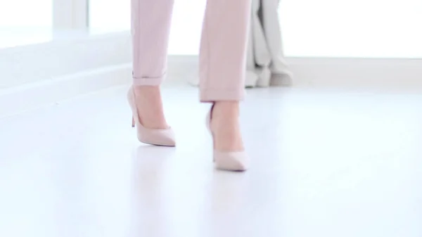 Fashionable woman wearing high heel shoes. Fashionable woman in high-heeled shoes. soft focus woman walking on white wooden floor.