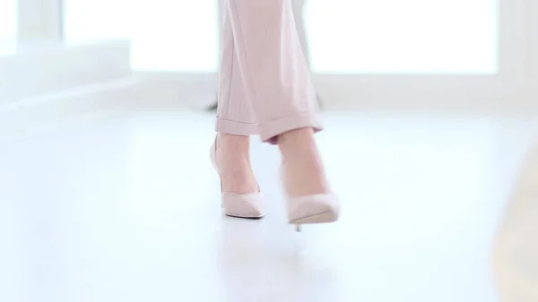 Mulher elegante usando sapatos de salto alto. Mulher na moda em sapatos de salto alto. mulher foco suave andando no chão de madeira branca. — Fotografia de Stock