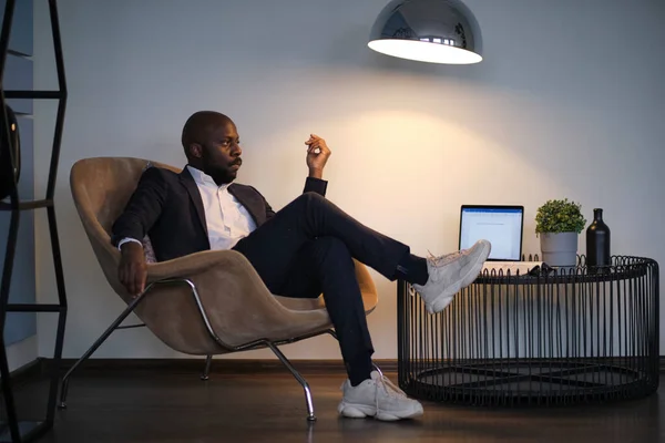 Portrait of a young African American man in a suit sitting in a chair. soft focus — Stock Photo, Image