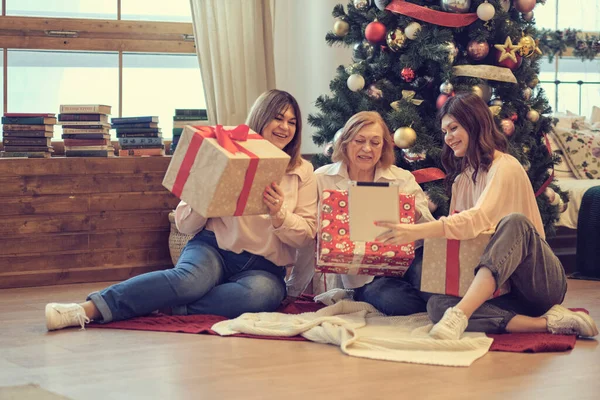 family of different generations show gifts to their friends via video link. video call on the tablet. We keeping our family traditions alive during the Christmas. soft focus