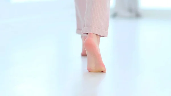 側は、認識できない女性の足の足のビューを閉じると、裸足の少女室内の近代的な家の中に立って暖かい木製の加熱された床をお楽しみください。ソフトフォーカス — ストック写真