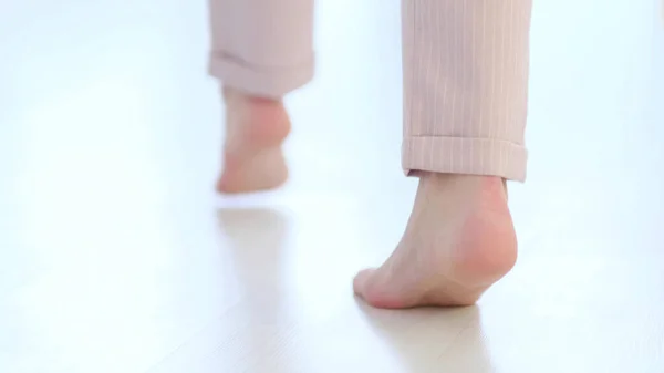 Vista lateral de cerca de piernas de pies de mujer irreconocibles, chica descalza de pie en el interior de la casa moderna disfrutar de suelo caliente de madera caliente. enfoque suave — Foto de Stock