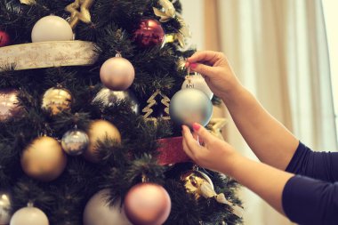 Güzel sarışın kadın Noel ağacını süslüyor.