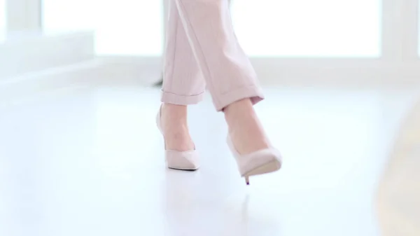 Mulher elegante usando sapatos de salto alto. Mulher na moda em sapatos de salto alto. mulher foco suave andando no chão de madeira branca. — Fotografia de Stock