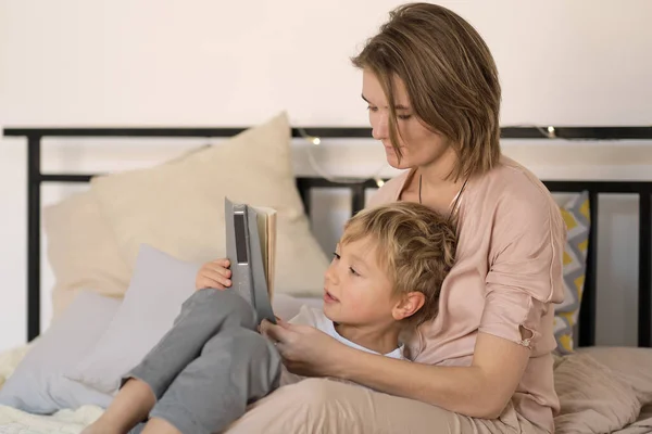 Mor läser en intressant historia för sin son. Verkliga känslor. — Stockfoto