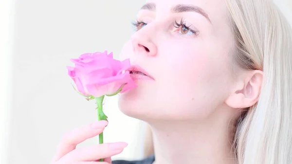 Gyönyörű fiatal nő, finom rózsa virággal. A lány tiszta, friss bőre megérinti az arcát virágokkal. lágy fókusz, szelektív fókusz — Stock Fotó