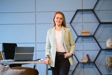 Gülümseyen olgun orta yaşlı iş kadını. Boş bir ofiste durmuş başka tarafa bakan mutlu yaşlı bir iş kadını. İş, başarı, insanlar, ofis