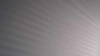 Duvarda hareket eden bulanık koyu gölgeler. Ürkütücü gölge sanat gürültü dokusu. Beyaz duvar dokusu arkaplanındaki lath ışığı gölge bataryasının hareketini kapat