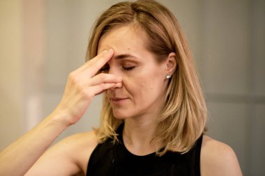 Burun deliğini değiştirerek nefes almak. Orta yaşlı kadın nefes egzersizleri yapıyor yoga, meditasyon, pranayama. Yakın plan, parmaklar burnu kapatır, Nadi Shodhana nefes alır.