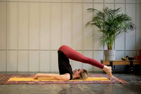 Žena středního věku jóga asanas. instruktor ukazuje pózu z jógy. žena praktikující koncepci jógy přirozená rovnováha mezi tělem a duševním vývojem. — Stock fotografie