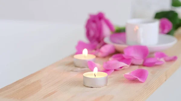 Piękne uzdrowisko z różową świecą i kwiatami na drewnianym tle. Koncepcja leczenia spa w salonie. Atmosfera relaksu, spokoju i przyjemności. Luksusowy styl życia. — Zdjęcie stockowe