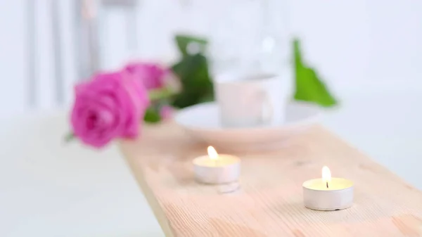 Hermoso entorno de spa con vela rosa y flores sobre fondo de madera. Concepto de tratamiento de spa en el salón. Ambiente de relax, serenidad y placer. Estilo de vida de lujo. — Foto de Stock