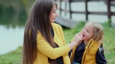 Güzel genç bir kadın ve büyüleyici küçük kızı parkta eğleniyor. Kızı doğada annesine sarılıyor.