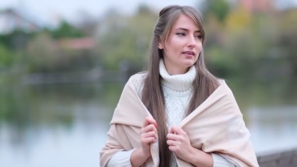 A mulher está lá fora ao pôr-do-sol dourado. Retrato da bela jovem mulher olhando para a câmera. close up Filmado vídeo. Filmagem em câmara lenta — Vídeo de Stock