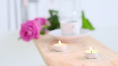 Pembe mum ve ahşap arka planda çiçekler olan güzel bir spa ortamı. Salonda spa tedavisi kavramı. Rahatlama, huzur ve zevk atmosferi. Lüks yaşam tarzı.