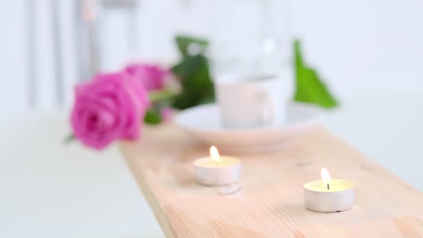 Όμορφο spa σκηνικό με ροζ κερί και λουλούδια σε ξύλινο φόντο. Έννοια της θεραπείας spa στο σαλόνι. Ατμόσφαιρα χαλάρωσης, γαλήνης και απόλαυσης. Πολυτελής τρόπος ζωής. — Αρχείο Βίντεο