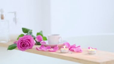 Pembe mum ve ahşap arka planda çiçekler olan güzel bir spa ortamı. Salonda spa tedavisi kavramı. Rahatlama, huzur ve zevk atmosferi. Lüks yaşam tarzı.