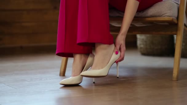 Mujer de negocios cansada se quita los zapatos después de un largo día. hinchazón de los pies después de tacones altos, enfoque suave. Enfoque selectivo. Vídeo en cámara lenta. Vídeo — Vídeo de stock