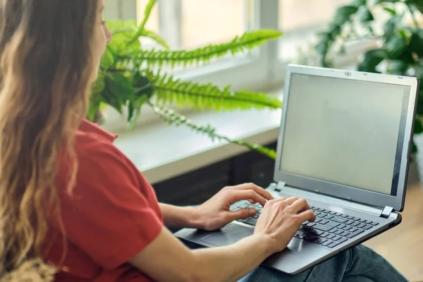 Visszapillantás felismerhetetlen nő használja laptop munka után, kommunikál az interneten az ügyféllel. Boldog szabadúszó nő pihentető kényelmes kanapén, és a laptop otthon. — Stock Fotó