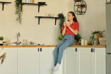 Genç bayan mutfakta temizlik yaptıktan sonra dinleniyor. Dairende bağımsız bir hayat. Kira için mükemmel bir daire bulma konsepti