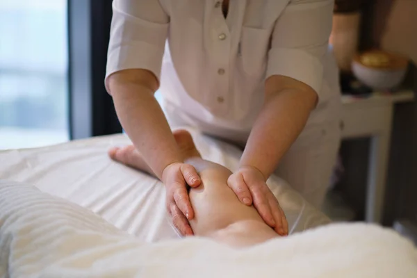 Detalhe das mãos massageando o músculo da panturrilha humana.Terapeuta aplicando pressão na perna feminina. Mãos de massagista massagista massageando pernas de mulher jovem no salão de spa. Cuidados com o corpo no salão de spa para mulher jovem. — Fotografia de Stock