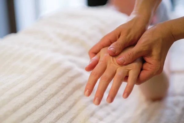 Polsmassage. massagetherapeut legt druk op een gevoelig punt op een vrouwenhand. Fysiotherapeut masseert haar patiënten hand in medisch kantoor — Stockfoto