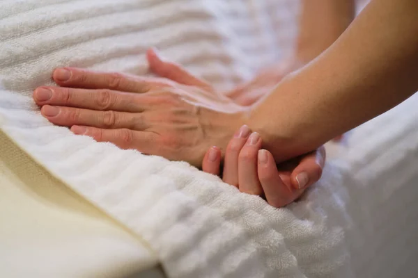 Handleden massage. Massageterapeuten sätter press på en känslig punkt på en kvinnas hand. Sjukgymnast masserar sina patienter handen i läkarmottagningen — Stockfoto