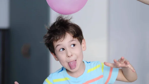 Surprised cheerful boy with thorns in his hair without static electrification. Physics, electrical electrification balloon test. Positively and negatively charged atoms. School lesson experiment. — Stock Photo, Image