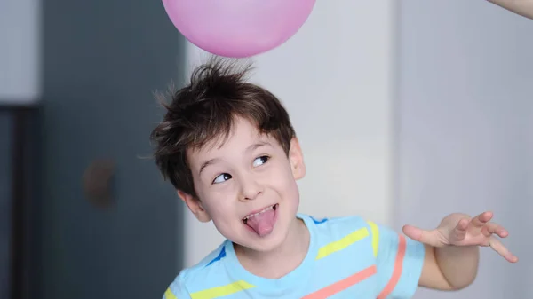 Überraschter fröhlicher Junge mit Dornen im Haar ohne statische Elektrifizierung. Physik, Elektrifizierung Ballontest. Positiv und negativ geladene Atome. Experiment Schulstunde. — Stockfoto