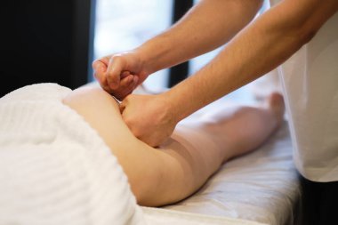 Masör spa salonundaki genç bayana antielülit masajı yapıyor. Vücut bakımı konsepti. Özel anti-elülit tedavisi.