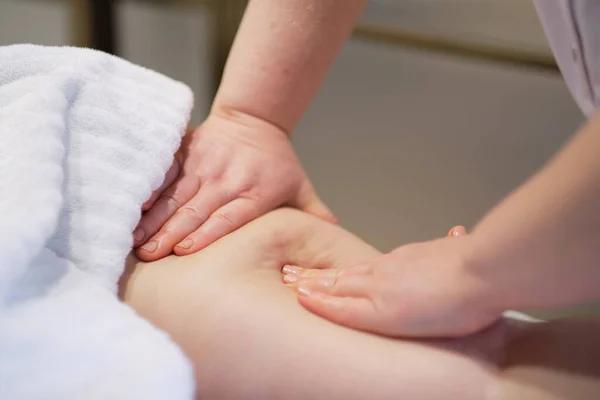 Masajista hace anticelulitis masaje mujer joven en el salón de spa. Concepto de cuidado corporal. Tratamiento especial contra la celulitis. — Foto de Stock