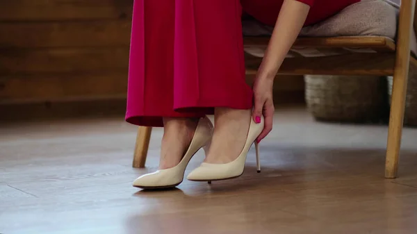 Tired business woman takes off her shoes after a long day. swelling of feet after high heels, soft focus. Selective focus. — Stock Photo, Image