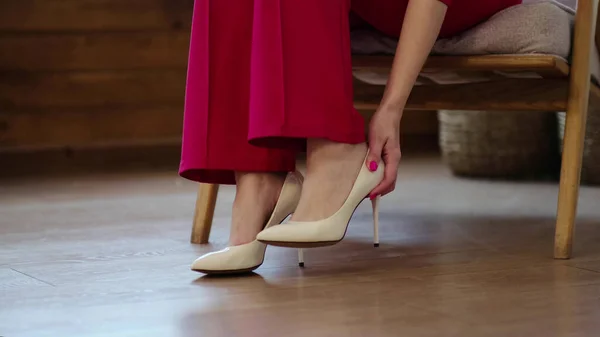 Zmęczona bizneswoman zdejmuje buty po długim dniu. obrzęk stóp po wysokich obcasach, miękkie skupienie. Skupienie selektywne. — Zdjęcie stockowe