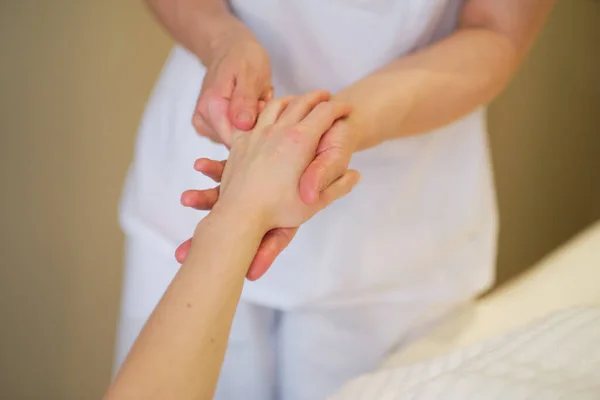 Polsmassage. massagetherapeut legt druk op een gevoelig punt op een vrouwenhand. Fysiotherapeut masseert haar patiënten hand in medisch kantoor — Stockfoto