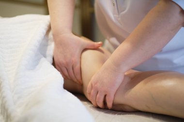 Vücut bakımı konsepti. Özel anti-elülit tedavisi. Masör spa salonundaki genç bayana antielülit masajı yapıyor. Görüntüyü kapat