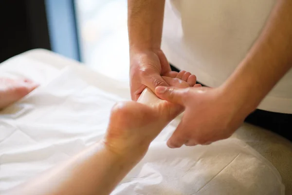 Ontspannende massage op de voet in spa salon binnen. — Stockfoto