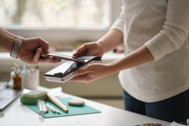 NFC teknolojisi. Müşteri ödüyor. Bir barda ulaşılamaz bir ödeme yaparken akıllı telefon kullanarak misafirleri kapatın..