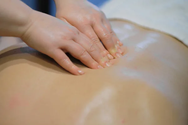 Zbliżenie mężczyzny korzystającego z relaksującego masażu pleców. Mężczyzna relaksujący się na stole do masażu otrzymujący masaż — Zdjęcie stockowe