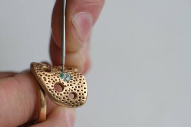 Makro atış. Mücevher yapımı. Yüzük tamir ediliyor. Elması yüzüğe takıyorum. Profesyonel aletlerle mücevher yapımı için masaüstü.