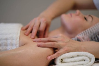 Güzel bir kızın güzellik kliniğinde yüz masajı var. Cilt bakımı, spa konsepti, tedavi. Yüz masajı. Yüz derisi. Masörün elleri. Güzellik salonundaki kadın..